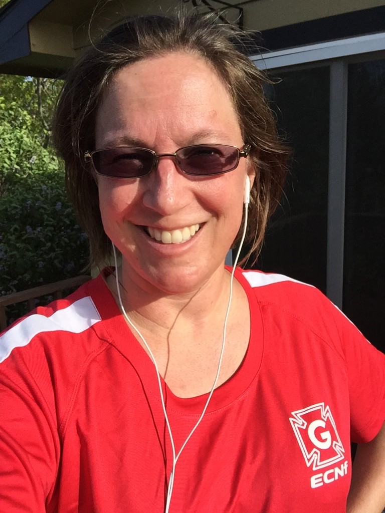 Photo, from the head up, of the blogger, sweaty and smiling. She is wearing a red and white shirt.